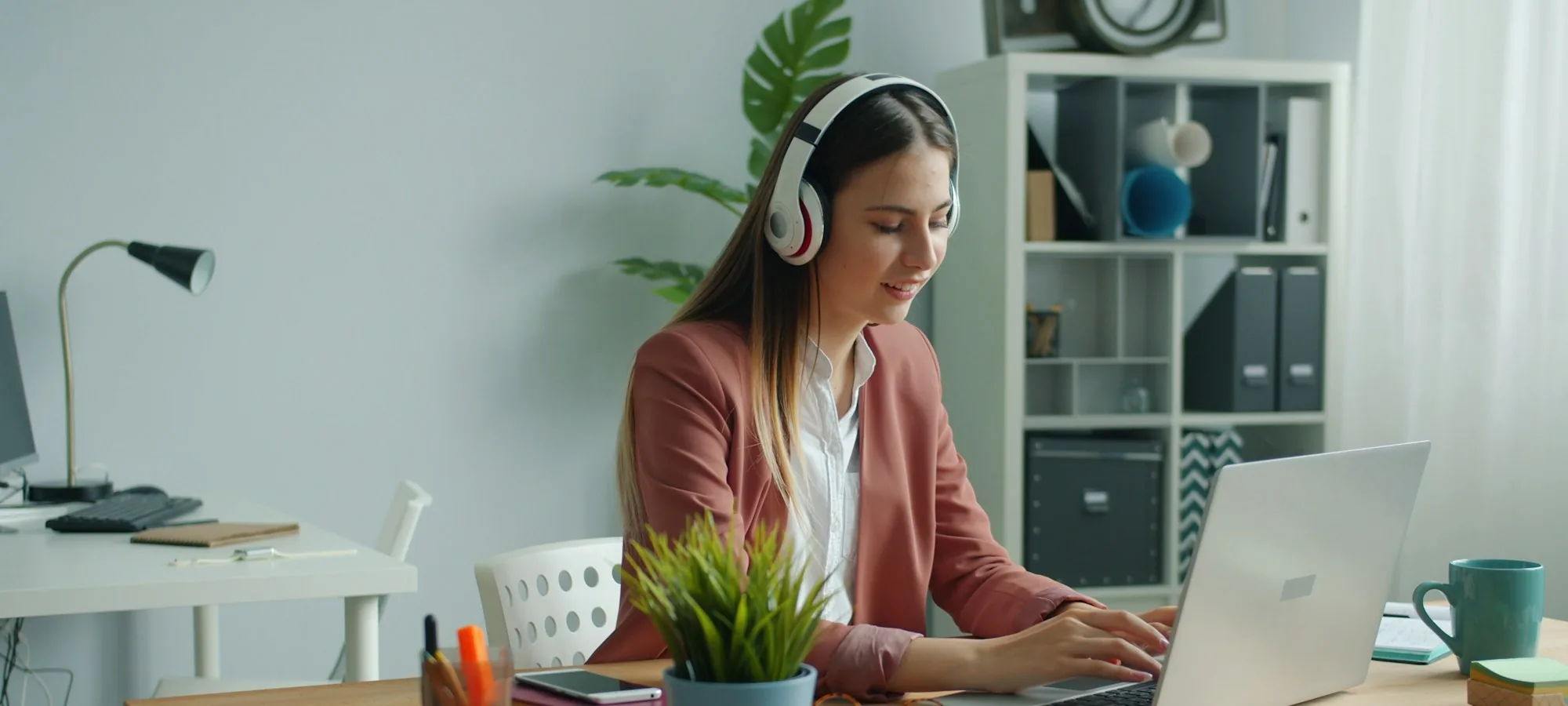 Eine Frau mit Kopfhörern lernt am Laptop