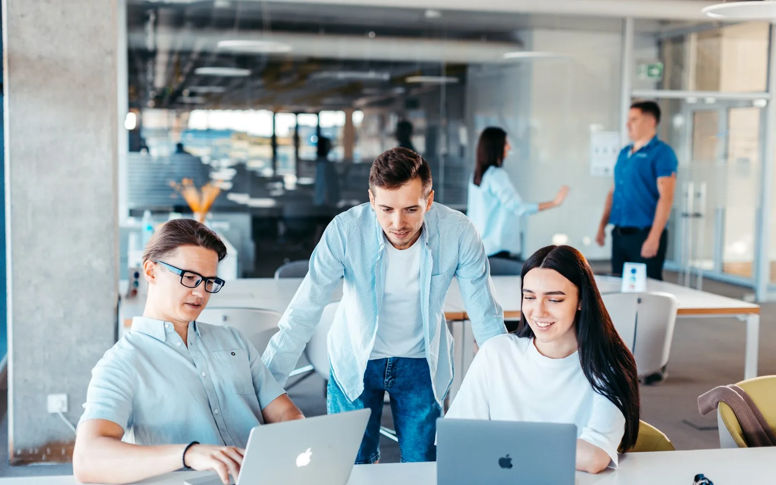 Ein Team arbeitet gemeinsam an Laptops